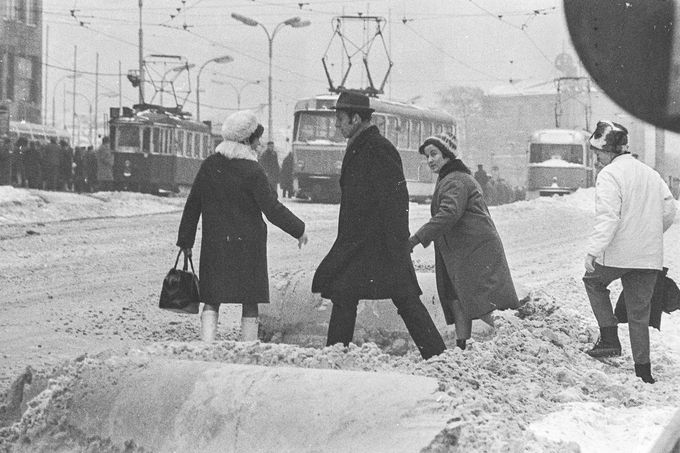 Zima 1969 / 1970 v Brně: Chodci přecházejí zasněženou ulici, zatímco tramvaje se pohybují pomalu kvůli sněhové kalamitě.