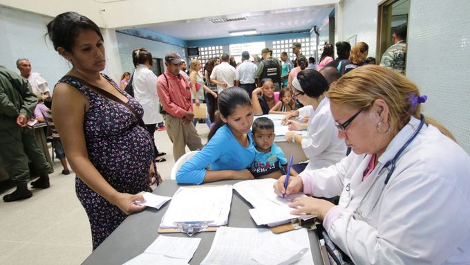 Lékařka pomáhá lidem, kteří hledají léčbu malárie ve zdravotním středisku v San Felixu ve Venezuele.