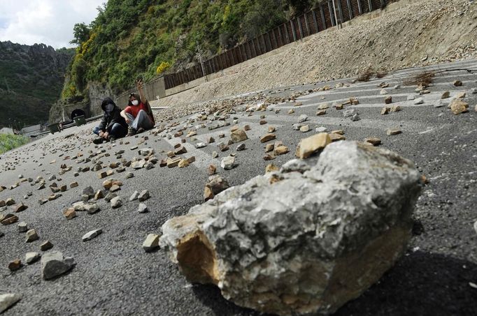 A coal miner shows a victory sign as he sits with a fellow miner on a road covered with stones after clashes with the Guardia Civil in Cinera village near Leon, northern Spain June 19, 2012. The miners were protesting against the government's proposal to decrease funding for coal production. REUTERS/Eloy Alonso (SPAIN - Tags: BUSINESS EMPLOYMENT POLITICS CIVIL UNREST TPX IMAGES OF THE DAY) Published: Čer. 19, 2012, 3:17 odp.