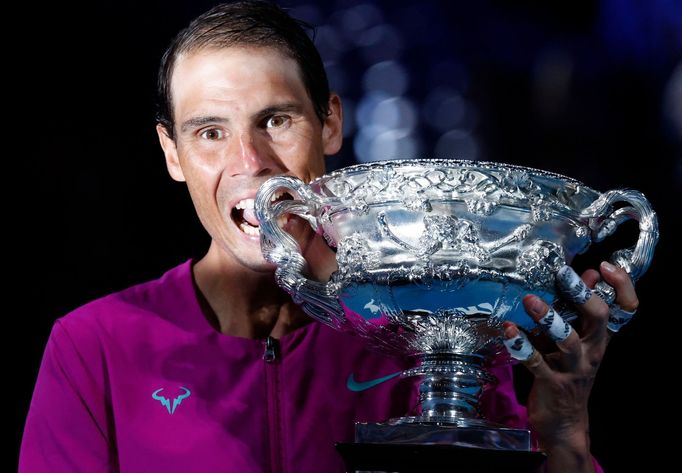 Tennis - Australian Open - Men's Singles Final - Melbourne Park, Melbourne, Australia - January 31, 2022 Spain's Rafael Nadal bites the trophy to celebrate winning the me