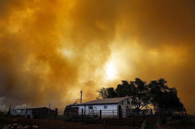 Smoke fills the air over a small barn turning the sky orange as the High Park Fire burns near Laporte, Colorado June 10, 2012. The fire started on Saturday and was estimated at more than 14,000 acres on Sunday morning. At least 18 structures were lost or damaged due to the fire with more threatened and officials are searching for one person believed to be missing. The cause of the fire is unknown and it remains at zero percent containment. REUTERS/Marc Piscotty (UNITED STATES - Tags: DISASTER ENVIRONMENT TPX IMAGES OF THE DAY) Published: Čer. 10, 2012, 11:55 odp.