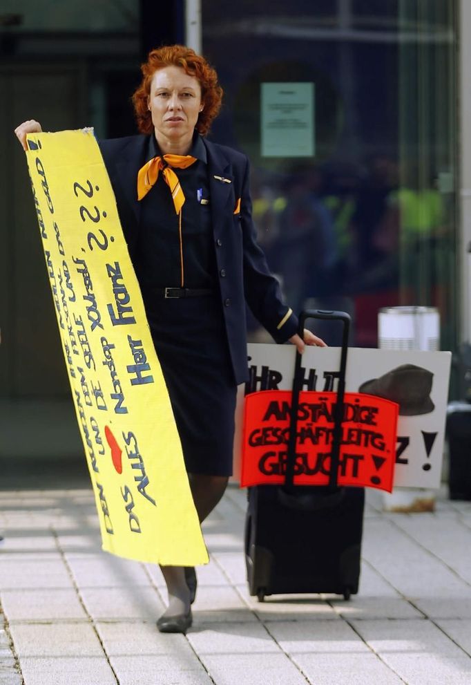 A member of Lufthansa's cabin crew union (UFO) arrives at a strike rally outside Munich Airport, September 4, 2012. Deutsche Lufthansa, Germany's biggest airline, cancelled hundreds of flights in Frankfurt, Berlin and Munich on Tuesday as cabin crew launched a second round of strikes in a row over pay and conditions. The strike action follows a walkout on Friday that left 26,000 passengers stranded and caused millions of euros in lost revenues. Sign reads, "decent management wanted". REUTERS/Michael Dalder(GERMANY - Tags: POLITICS BUSINESS EMPLOYMENT TRANSPORT CIVIL UNREST) Published: Zář. 4, 2012, 12:21 odp.