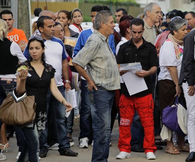 Luis Salgado (in red pants), nicknamed Chucho, holds his documents as he waits in line with other Cubans to apply for a visa at the U.S. Interests Section in Havana, January 31, 2013. Chucho's visa application, based on his father's status as legal resident in the U.S., was approved and he was reunited in Miami with his father, Jesus Salgado, who had escaped Cuba on a frail boat ten years earlier. The Salgados are among many Cubans taking advantage of Cuba's new travel policy in place since last January, which allows citizens to leave the country with just a passport and no need for much-hated exit visas required since 1961. Picture taken January 31, 2013. REUTERS/Desmond Boylan (CUBA - Tags: POLITICS SOCIETY) Published: Dub. 11, 2013, 12:50 odp.