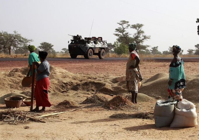 Malian women look at a French military vehicle drive past, as part of a convoy of French military vehicles including armored personnel carriers, jeeps and supply trucks, heading toward the recently liberated town of Diabaly January 24, 2013. REUTERS/Eric Gaillard (MALI - Tags: CIVIL UNREST CONFLICT MILITARY) Published: Led. 24, 2013, 5:30 odp.