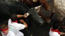 A runner grabs the horn of a Dolores Aguirre fighting bull on Santo Domingo hill during the first running of the bulls of the San Fermin festival in Pamplona July 7, 2012. A runner was gored in the leg during the run that lasted two minutes and fifty three seconds, according to local media. REUTERS/Susana Vera (SPAIN - Tags: SOCIETY ANIMALS) Published: Čec. 7, 2012, 7:13 dop.