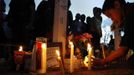 A boy lights a candle at a memorial for victims behind the theater where a gunman opened fire last Friday on moviegoers in Aurora, Colorado July 22, 2012. President Barack Obama travelled to Colorado on Sunday to meet families bereaved after a gunman went on a shooting rampage at a movie theater in a Denver suburb, killing at least 12 people and wounding 58. REUTERS/Shannon Stapleton (UNITED STATES - Tags: CRIME LAW CIVIL UNREST OBITUARY TPX IMAGES OF THE DAY) Published: Čec. 23, 2012, 3:22 dop.