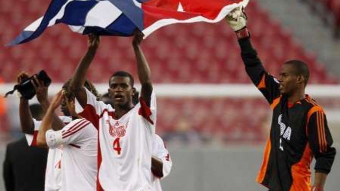 Kubánský fotbalista Raicel Mazquia Pozo (vlevo) drží s reprezentačním brankářem státní vlajku po porážce od Hundurasu v olympijské kvalifikaci v Tampě.