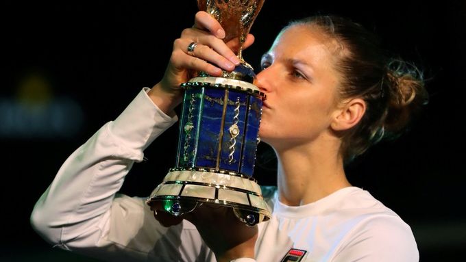 Karolína Plíšková líbá jednu vítěznou trofej za druhou.