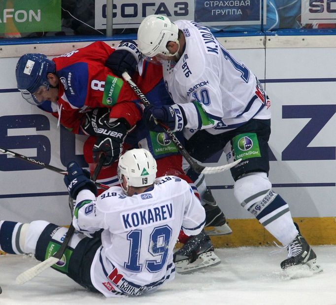 Hokejisté Dynama Moskva Děnis Kokarev (na ledě) a Konstantin Volkov bojují s Michalem Sersenem v utkání KHL 2012/13 proti Lvu Praha.