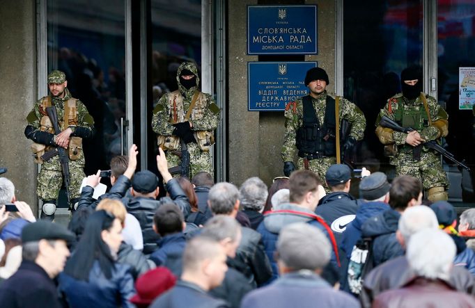 Pro-Russian armed men stand guard as pro-Russian supporters gather outside the mayor's office in Slaviansk April 14, 2014.