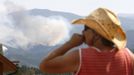 Jessie Couillard, whose home was under a pre-evacuation notice, watches the High Park fire only a few miles from her home in Glacier View Meadows, northwest of Fort Collins, Colorado June 18, 2012. The fire has charred more than 85 square miles (200 square km) and sent a plume of smoke billowing thousands of feet into the air. The lightning-sparked blaze has destroyed 181 homes since it was reported June 9, ranking it as the most destructive wildfire on record in Colorado. REUTERS/Rick Wilking (UNITED STATES - Tags: DISASTER ENVIRONMENT) Published: Čer. 18, 2012, 11:26 odp.