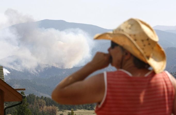 Jessie Couillard, whose home was under a pre-evacuation notice, watches the High Park fire only a few miles from her home in Glacier View Meadows, northwest of Fort Collins, Colorado June 18, 2012. The fire has charred more than 85 square miles (200 square km) and sent a plume of smoke billowing thousands of feet into the air. The lightning-sparked blaze has destroyed 181 homes since it was reported June 9, ranking it as the most destructive wildfire on record in Colorado. REUTERS/Rick Wilking (UNITED STATES - Tags: DISASTER ENVIRONMENT) Published: Čer. 18, 2012, 11:26 odp.