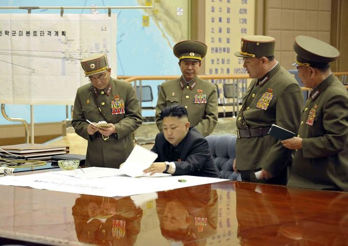 North Korean leader Kim Jong-un (C) presides over an urgent operation meeting on the Korean People's Army Strategic Rocket Force's performance of duty for firepower strike at the Supreme Command in Pyongyang, early March 29, 2013, in this picture released by the North's official KCNA news agency on Friday. North Korea put its rocket units on standby on Friday to attack U.S. military bases in South Korea and the Pacific, after the United States flew two nuclear-capable stealth bombers over the Korean peninsula in a rare show of force. Kim Jong-un signed off on the order at a midnight meeting of top generals and "judged the time has come to settle accounts with the U.S. imperialists in view of the prevailing situation", the official KCNA news agency said. The sign on the left reads, "Strategic force's plan to hit the mainland of the U.S.".