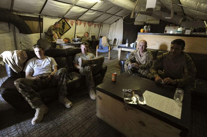 Britain's Prince Harry (2nd L) relaxes with fellow Apache crew members Captain Simon Beattie (L), and Sergeant James John (2nd R) at Camp Bastion, southern Afghanistan in this photograph taken November 3, 2012, and released January 21, 2013. The Prince, who is serving as a pilot/gunner with 662 Squadron Army Air Corps, is on a posting to Afghanistan that runs from September 2012 to January 2013. Photograph taken November 3, 2012. REUTERS/John Stillwell/Pool (AFGHANISTAN - Tags: MILITARY POLITICS SOCIETY MEDIA ROYALS CONFLICT) Published: Led. 21, 2013, 9:40 odp.