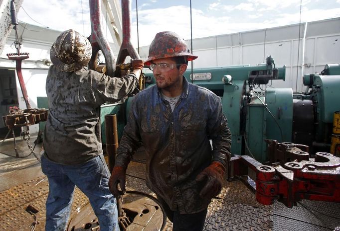 Roughneck Brian Waldner is covered in mud and oil while wrestling pipe on a True Company oil drilling rig outside Watford, North Dakota, October 20, 2012. Thousands of people have flooded into North Dakota to work in state's oil drilling boom. Picture taken October 20, 2012. REUTERS/Jim Urquhart (UNITED STATES - Tags: ENERGY BUSINESS EMPLOYMENT) Published: Říj. 22, 2012, 1:40 odp.