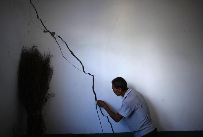 Ma Tianxin looks at the cracked walls of his house after a landslide near Badong, on the bank of the Yangtze River, 100km (62 miles) from the Three Gorges dam in Hubei province August 7, 2012. China relocated 1.3 million people during the 17 years it took to complete the Three Gorges dam. Even after finishing the $59 billion project last month, the threat of landslides along the dam's banks will force tens of thousands to move again. It's a reminder of the social and environmental challenges that have dogged the world's largest hydroelectric project. While there has been little protest among residents who will be relocated a second time, the environmental fallout over other big investments in China has become a hot-button issue ahead of a leadership transition this year. Picture taken on August 7, 2012. To match story CHINA-THREEGORGES/ REUTERS/Carlos Barria (CHINA - Tags: POLITICS ENVIRONMENT BUSINESS ENERGY) Published: Srp. 22, 2012, 8:17 odp.