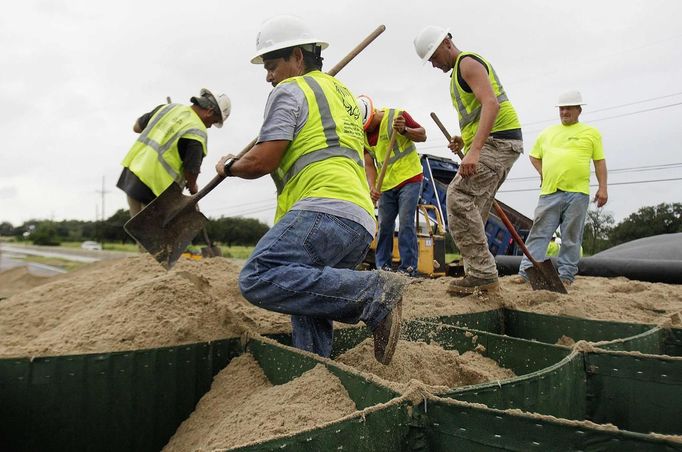 HESCO employees work at closing off Highway 23 South as Tropical Storm Isaac heads towards the Louisiana coast line in Oakville, Louisiana, August 28, 2012. Tropical Storm Isaac was near hurricane force as it bore down on the U.S. Gulf Coast on Tuesday and was expected to make landfall in the New Orleans area seven years after it was devastated by Hurricane Katrina. REUTERS/Sean Gardner (UNITED STATES - Tags: ENVIRONMENT BUSINESS EMPLOYMENT DISASTER TRANSPORT) Published: Srp. 28, 2012, 1:58 odp.