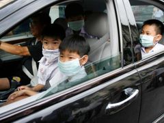 Rodiče si odvážejí děti z privátní školy v Bangkoku. Škola byla kvůli nebezpečí prasečí chřipky uzavřena.