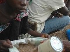 Liberijská dívka v humanitárním táboře rozděluje jídlo. Jiné dívky v jejím věku za jídlo nabízejí své tělo, varuje humanitární organizace Save the children