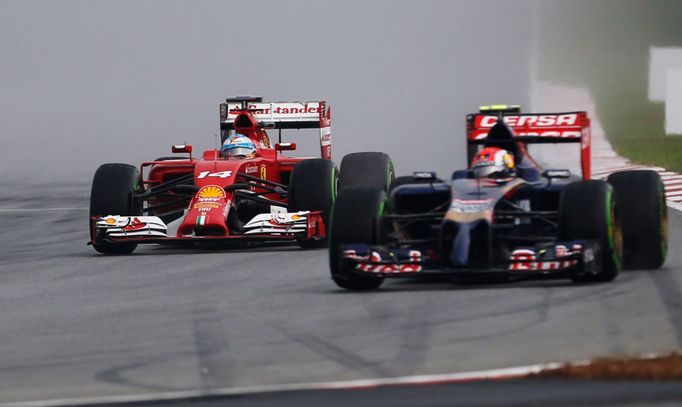 Ferrari Formula One driver Fernando Alonso of Spain drives near Toro Rosso Formula One driver Daniil Kvyat of Russia during the qualifying session for the Malaysian F1 Gr