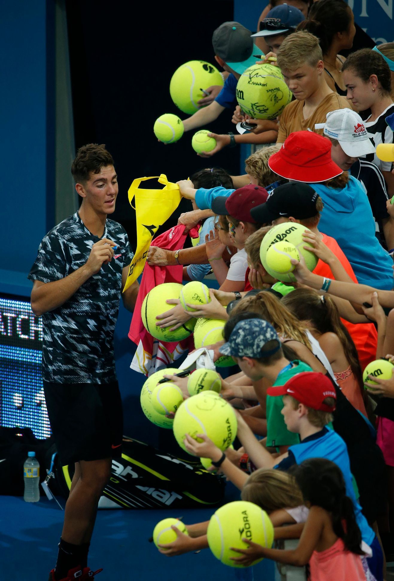 Kokkinakis of Australia signs autographs for fans following his first round victory over Benneteau of France at the Brisbane International tennis tournament in Brisbane