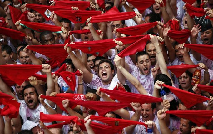 Revellers hold up their red scarves during the start of the San Fermin Festival in Pamplona July 6, 2012. The annual festival, best known for its daily running of the bulls, kicked off on Friday with the traditional "Chupinazo" rocket launch and will run until July 14. REUTERS/Susana Vera (SPAIN - Tags: ANNIVERSARY SOCIETY TPX IMAGES OF THE DAY TRAVEL) Published: Čec. 6, 2012, 1:57 odp.