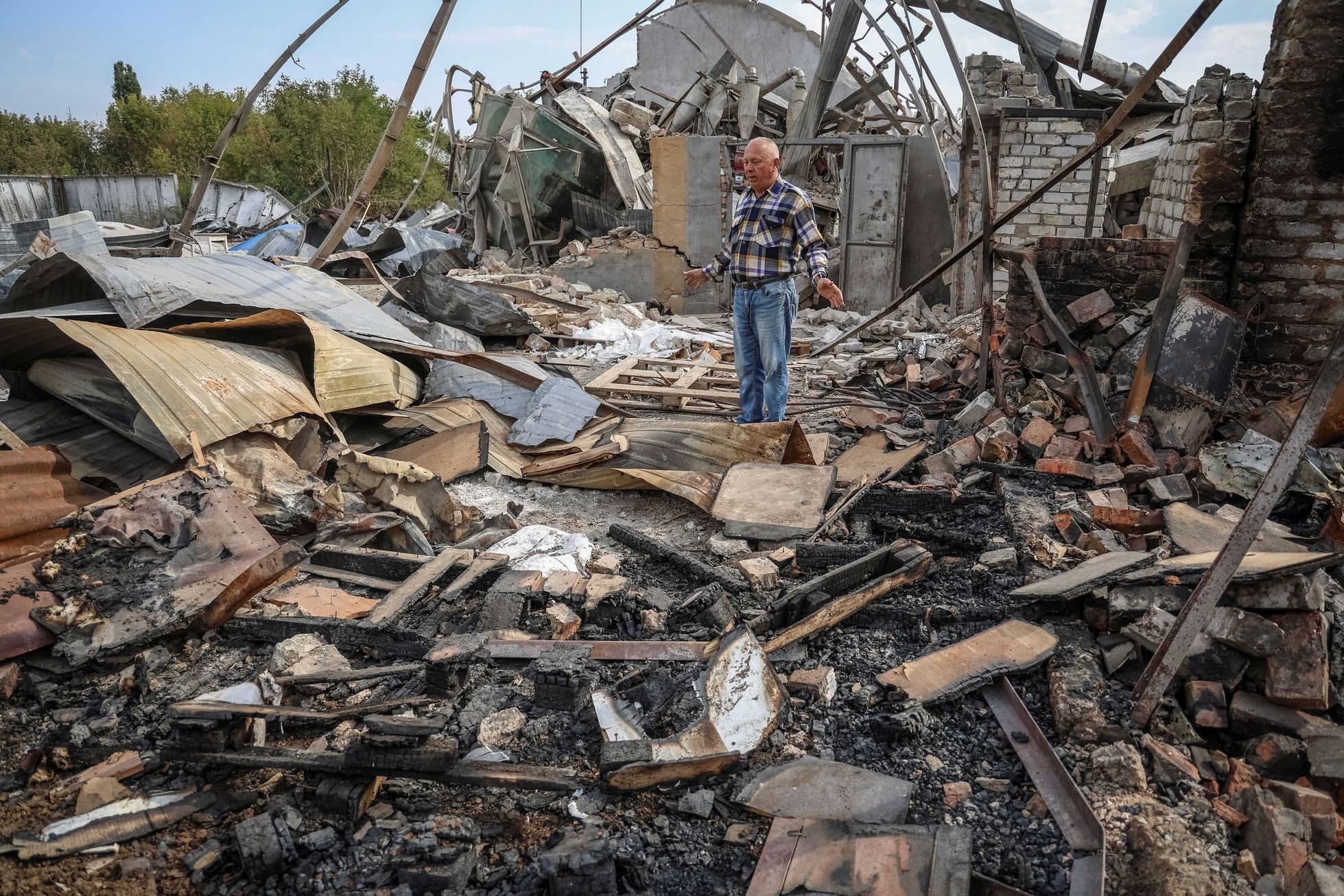 Sedmašedesátiletý Jakiv Marynčenko na svém pozemku, zničeném ruském bombardováním města Orichiv v Záporožské oblasti.