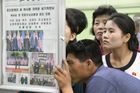 Severokorejci čtou noviny popisující summit Kima s Trumpem