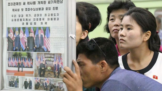 Severokorejci čtou noviny popisující summit Kima s Trumpem