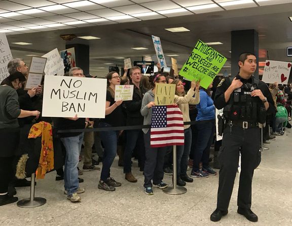 Cestující protestují na Dullesově mezinárodním letišti ve Washingtonu.