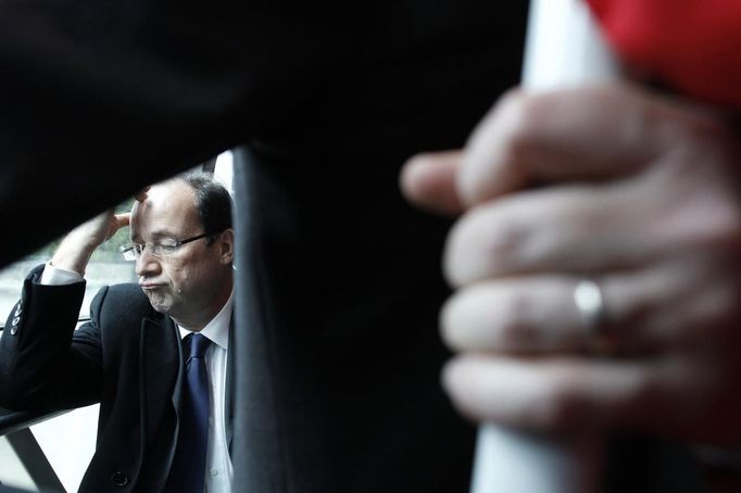 Hollande, French Socialist Party candidate for the 2012 presidential elections, reacts as he takes a local bus during a campaign visit in Vaulx-en-Velin