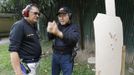 Jaime "Jimmy" Santiago (L), a lower court judge in Manila, talks to his fellow court judge Armando Yanga while checking a target cardboard during their shooting practice at a police firing range in Manila March 6, 2013. Santiago, a former police officer who headed a special weapons and tactics (SWAT) unit, favours arming Filipino judges to protect themselves from disgruntled litigants who can't accept decisions and criminal syndicates whose members were sent to jail. There had been cases of shootings inside courtrooms. Picture taken March 6, 2013. REUTERS/Romeo Ranoco (PHILIPPINES - Tags: POLITICS CRIME LAW) Published: Dub. 4, 2013, 11:20 dop.