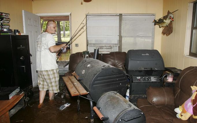 Troy Revis retrieves some fishing rods from his flooded home on County Road 137 in Wellborn, Florida, June 27, 2012. Revis said his family couldn't get flood insurance for the home because of a pond that was built behind it. "I'm sure will just bulldoze it and take a loss," he said. Tropical Storm Debby weakened to a tropical depression after it drifted ashore on Florida's Gulf Coast, even as it dumped more rain on flooded areas and sent thousands of people fleeing from rising rivers. REUTERS/Phil Sears (UNITED STATES - Tags: ENVIRONMENT DISASTER) Published: Čer. 27, 2012, 10:29 odp.