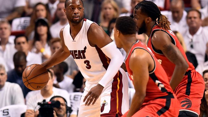 Miami Heat guard Dwyane Wade (3) is pressured by Toronto Raptors guard Kyle Lowry (7) and forward DeMarre Carroll (5)