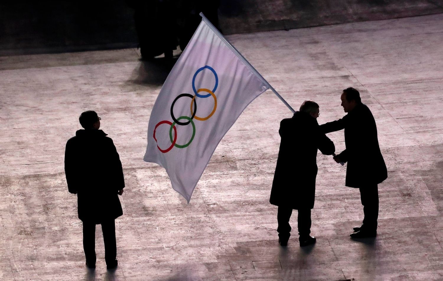 Slavností zakončení ZOH 2018: starosta Pchjongčchangu předává olympijskou vlajku starostovi Pekingu