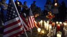 Myia Young, 4, places a candle by an American flag during a vigil for victims behind a theater where a gunman open fire at moviegoers in Aurora, Colorado July 20, 2012. A total of 71 people were shot in Friday's rampage at the Denver-area movie theater that has left 12 people dead, the local police chief said. The suspect, identified by police as James Eagan Holmes, 24, also booby-trapped his Aurora apartment with sophisticated explosives, creating a hazard for law-enforcement and bomb squad officers who swarmed to the scene. REUTERS/ Jeremy Papasso (UNITED STATES - Tags: CRIME LAW TPX IMAGES OF THE DAY) Published: Čec. 21, 2012, 5:57 dop.