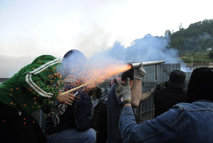 Coal miners fire a rocket during a clash with Spanish national riot police in the surroundings of the "El Soton" coal mine in El Entrego, near Oviedo, northern Spain June 15, 2012. The miners were protesting against the government's proposal to decrease funding for coal production. REUTERS/Eloy Alonso (SPAIN - Tags: CIVIL UNREST BUSINESS EMPLOYMENT ENERGY) Published: Čer. 15, 2012, 11:41 dop.