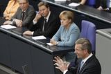 Christian Wulff mluví v Bundestagu poté, co složil přísahu. Naslouchají mu ministr vnitra Thomas De Maiziere, ministr zahraničí Guido Westerwelle a kancléřka Angela Merkelová (2. července 2010).