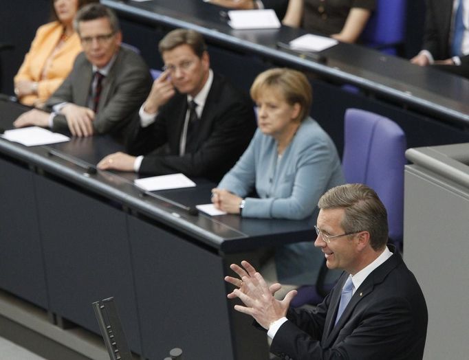 Christian Wulff mluví v Bundestagu poté, co složil přísahu. Naslouchají mu ministr vnitra Thomas De Maiziere, ministr zahraničí Guido Westerwelle a kancléřka Angela Merkelová. (2. července 2010)