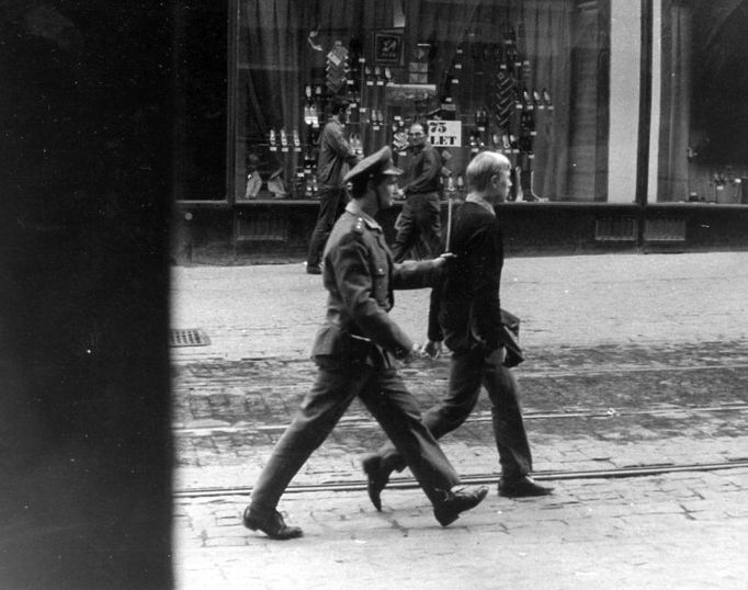 Příslušník VB odvádí zadrženého demonstranta