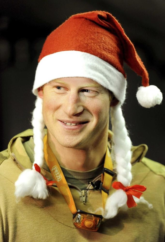 Britain's Prince Harry wears a Santa Claus hat as he shows media his sleeping area and bed at the VHR (very high readiness) tent at Camp Bastion, southern Afghanistan in this photograph taken December 12, 2012, and released January 21, 2013. The Prince, who is serving as a pilot/gunner with 662 Squadron Army Air Corps, is on a posting to Afghanistan that runs from September 2012 to January 2013. Photograph taken December 12, 2012. REUTERS/John Stillwell/Pool (AFGHANISTAN - Tags: MILITARY POLITICS SOCIETY ROYALS CONFLICT) Published: Led. 21, 2013, 7:40 odp.