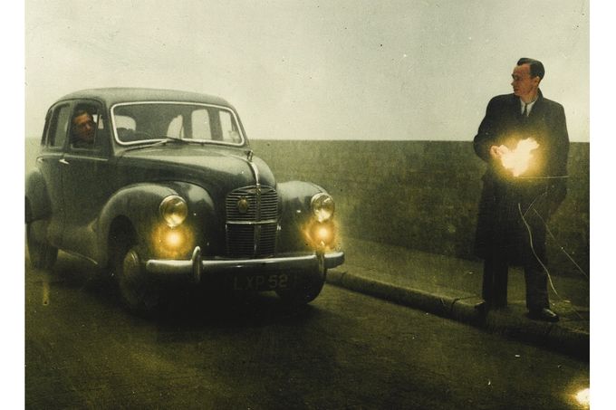 Muž s hořící pochodní naviguje automobil v Londýně, prosinec 1952. Viditelnost během Velkého smogu klesla na metry a doprava zcela zkolabovala. Kolorováno