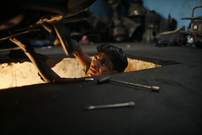 Palestinian Mohammed Jundeya, 17, works in a car repair garage in Gaza City May 30, 2013. Jundeya left school to work as an apprentice in the garage so that he could support his family's income. Apprentice mechanics earn around $100 per month, garage owners said. REUTERS/Mohammed Salem (GAZA - Tags: TRANSPORT SOCIETY EMPLOYMENT) Published: Kvě. 30, 2013, 12:54 odp.