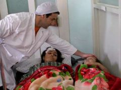 Lékař ošetřuje dívky, zraněné při sebevražedném útoku Talibanu v metropoli Kábulu.
