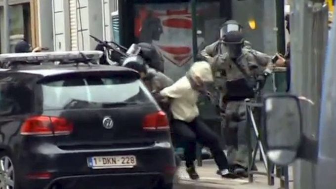 Belgická policie odvádí jednoho ze zadržených. Záběr z videozáznamu.