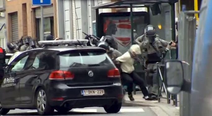 Belgická policie během razie v bruselské čtvrti Molenbeek, během níž byl dopaden i terorista z Paříže Salah Abdeslam. Snímek je pořízen z videozáznamu.