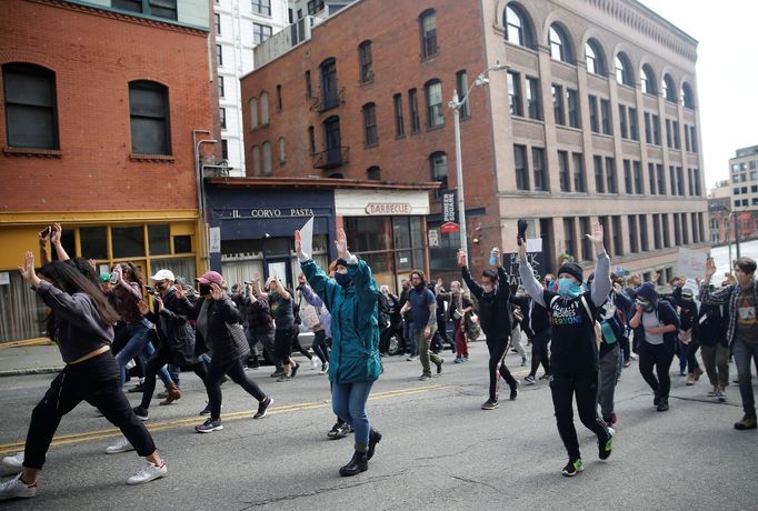 Protestující se zvednutýma rukama při pochodu městem, stát Washington, 31. května.