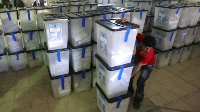 Pracovník sčítací komise v Bagdádu přesouvá krabice s odevzdanými volebními lístky.