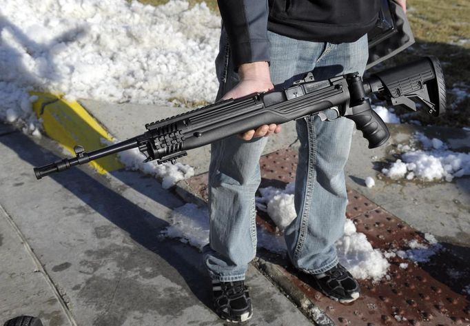 A man shows a Ruger Mini 14 rifle in .223 caliber that he purchased at a gun show in Kansas City, Missouri December 22, 2012. REUTERS/Dave Kaup (UNITED STATES - Tags: POLITICS SOCIETY) Published: Pro. 22, 2012, 8:12 odp.