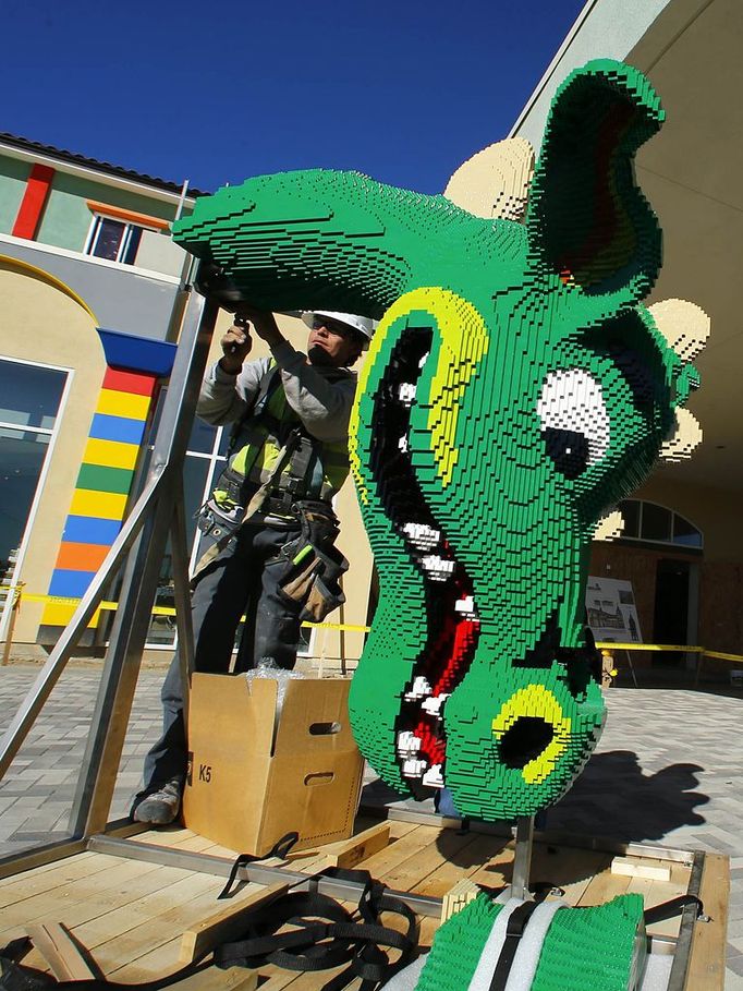 A worker prepares a dragon's head made of Lego bricks before it is hoisted into place as construction continues on North America's first ever Lego Hotel being built at Legoland in Carlsbad, California January 17, 2013. The three-storey, 250-room hotel will open April 5. REUTERS/Mike Blake (UNITED STATES - Tags: SOCIETY BUSINESS EMPLOYMENT TRAVEL) Published: Led. 17, 2013, 11:31 odp.